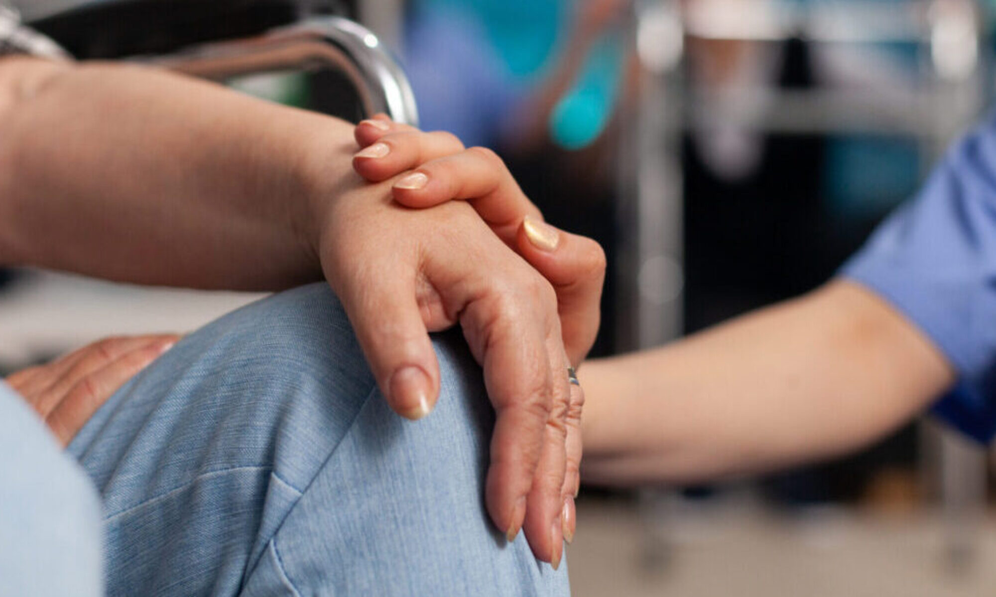 Social assistant worker consoling handicapped pensioner patient touching hands during homecare service. Healthcare support assistance. Social services nursing at home. Caregiver nurse